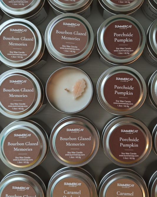 Multiple metallic tins of SummerCay Candle Company candles with various scents for fall.