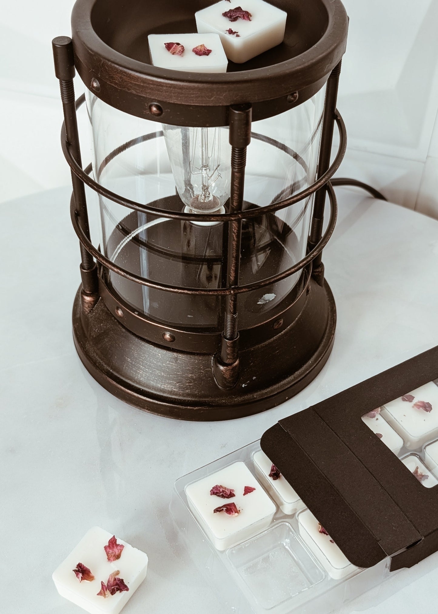 Vintage-style candle warmer with wax melts on a white surface