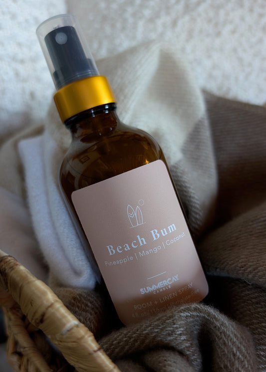 Beach Bum room spray in a woven basket with a soft blanket.