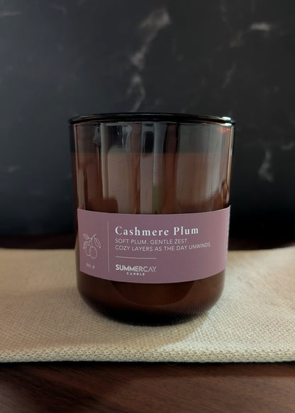 Candle with a muted purple label on a dark background
