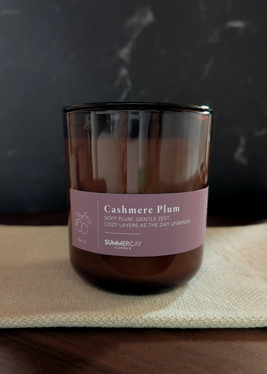 Candle with a muted purple label on a dark background