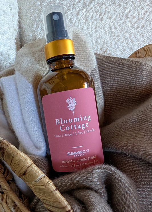 Blooming cottage room spray sitting in a woven basket with a soft blanket.