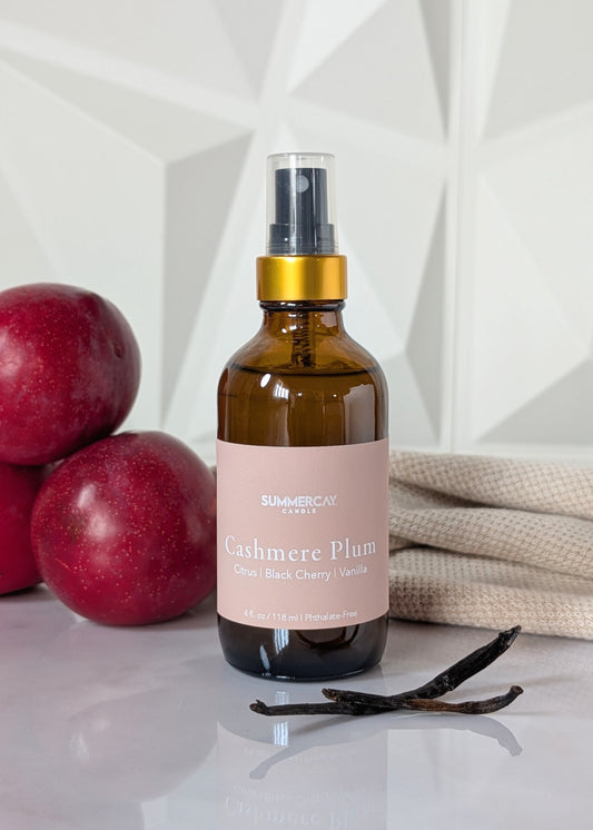 cashmere plum scented room and linen spray wit plums, soft fabric and vanilla on a white background. 