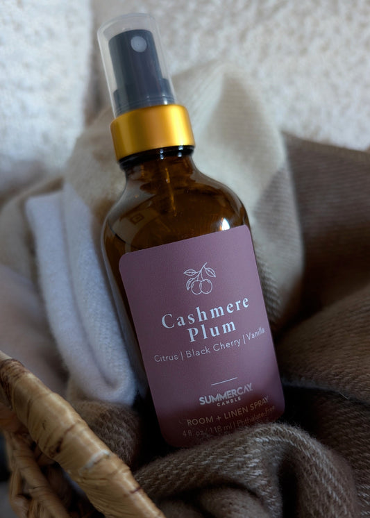 room spray sitting on a woven basket and blanket