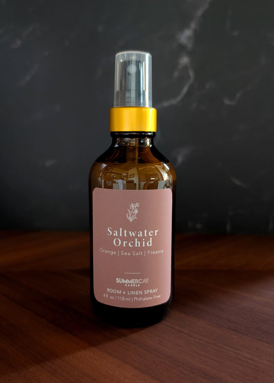 Saltwater Orchid Room spray sitting on a wooden table. 